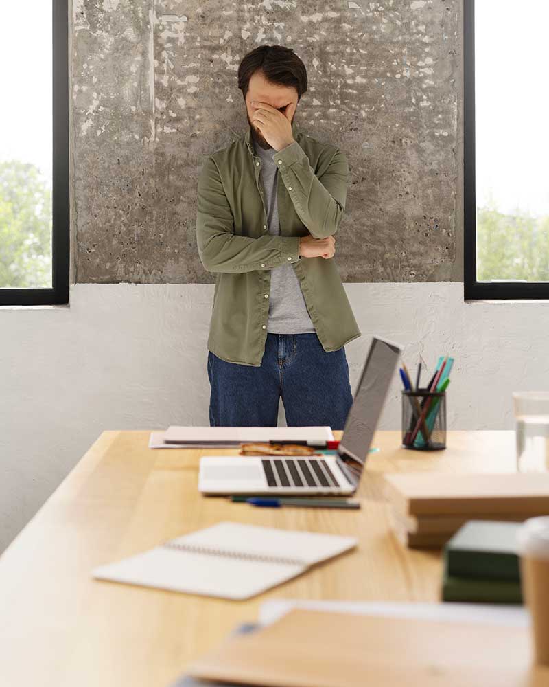 Stress sul lavoro: uomo stressato vicino alla scrivania